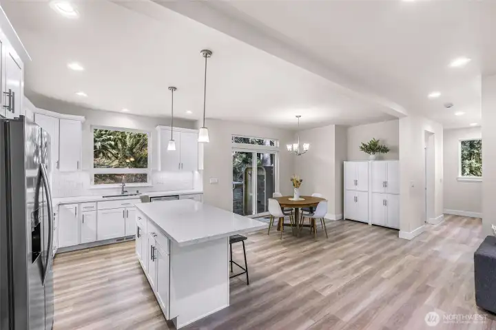 Kitchen featuring white cabinetry, quartz counters, tile backsplash, and functional layout.