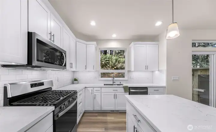 Kitchen with island seating, stainless appliances, and ample cabinet storage.