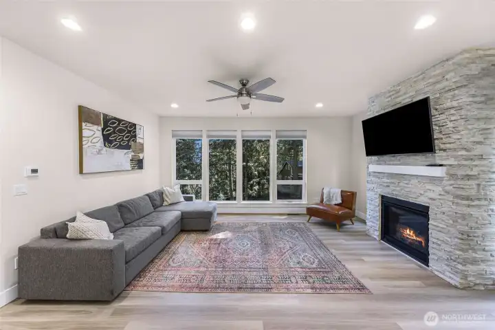 Living room with large windows, recessed lighting, and modern fireplace feature.