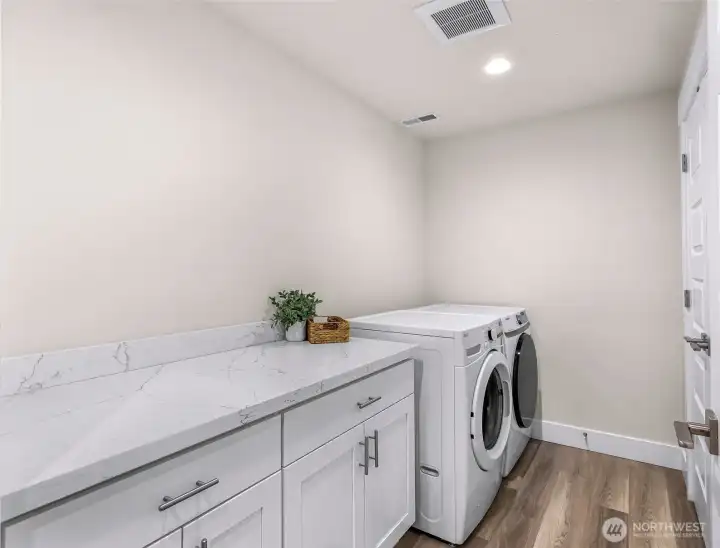 Laundry room with counter space, cabinetry, and side-by-side washer and dryer on the lower level.