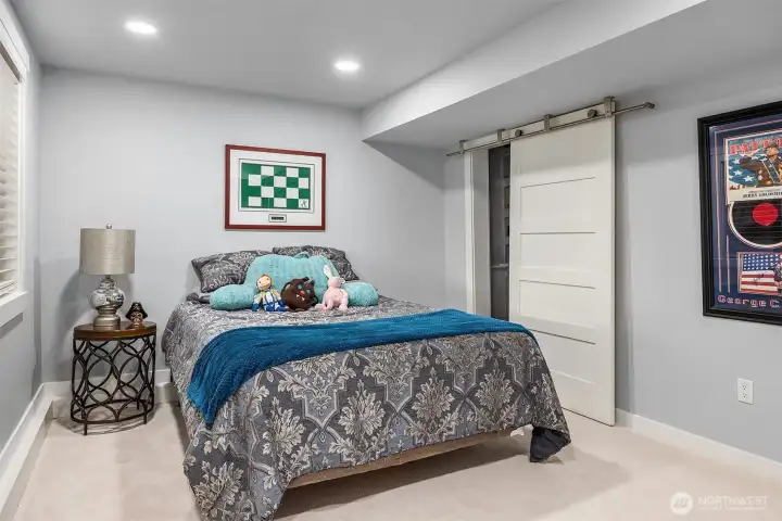 Lower level BR #4 with walk-in closet and door to outdoor patio and living spaces.