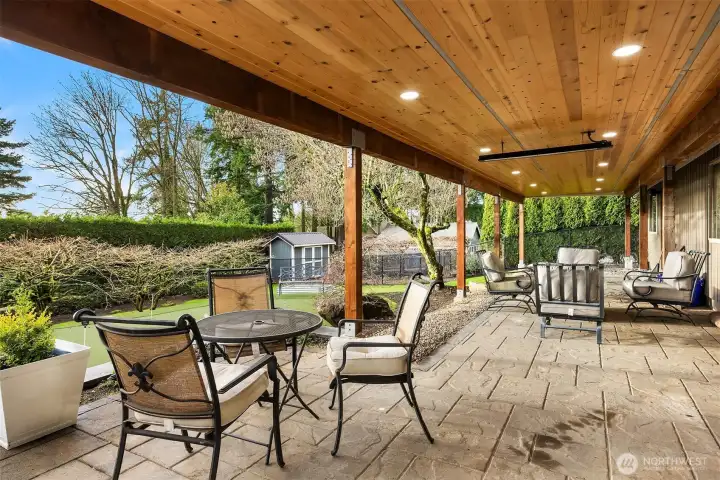 This fantastic stone patio enjoys a beautiful wood ceiling with lights and heaters for year round enjoyment.