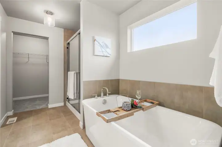 Ensuite bathroom includes large, soaking tub, shower, walk-in closet, vanity, and WC.