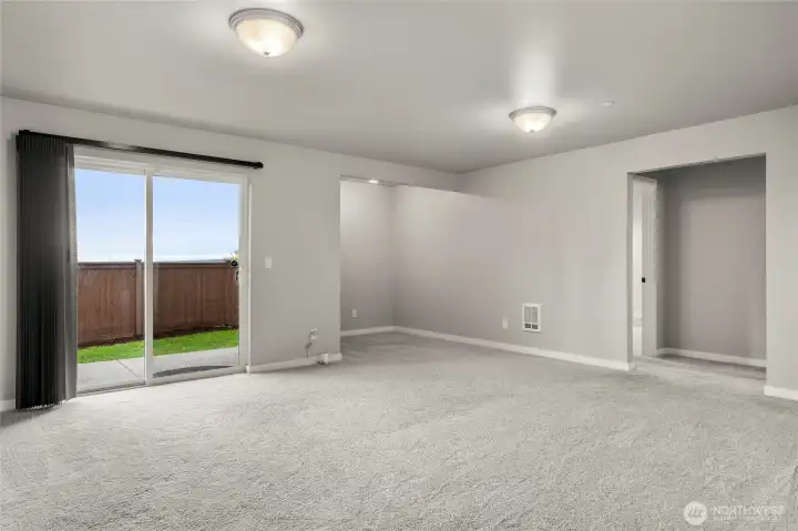 The large basement family room opens onto a patio and fenced backyard. Another bedroom and full bath are through the right opening.