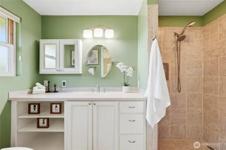 The fully wheelchair-accessible bathroom is a standout feature rarely found in homes of this era. A curbless roll-in tile shower provides easy, barrier-free access.