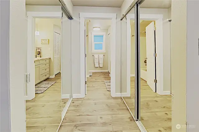 Hallway to primary bathroom, with closets on both sides