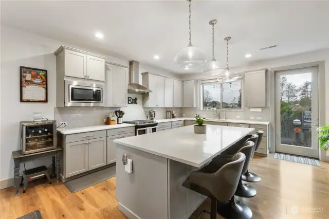 Kitchen has quartz counters, stainless appliances and custom tile backsplash.