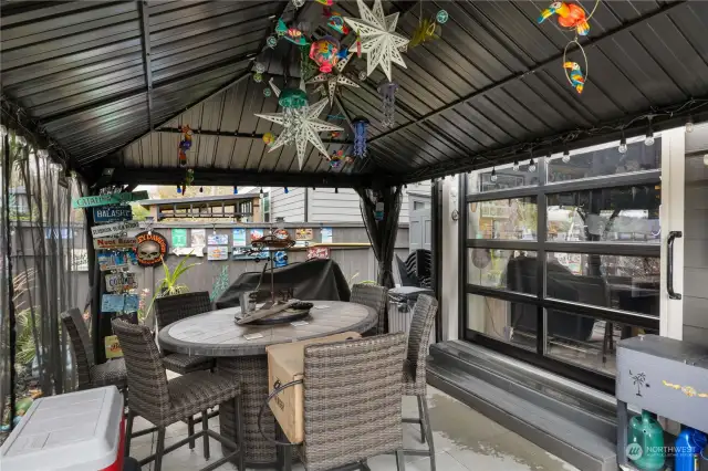 Gazebo stays with the home and added back garage door opens to create the perfect entertaining and bar area out back.