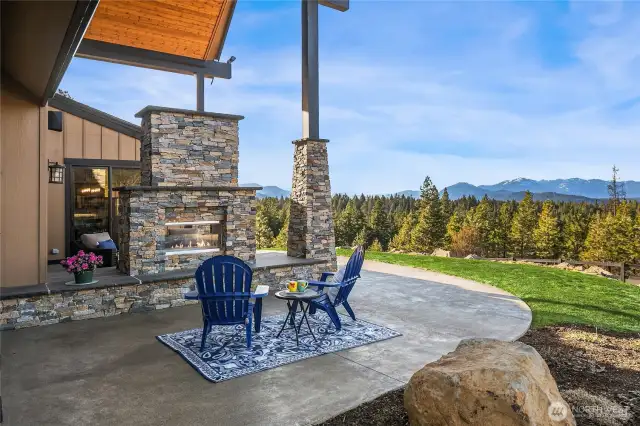 Just off the primary bedroom is another private fireplace area connected to the hot tub patio. (grass color enhanced to show summer season)