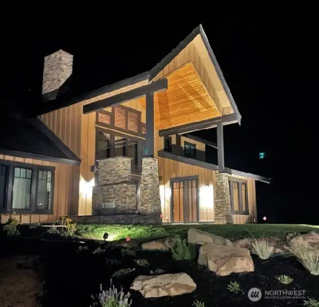 Outdoor patio with fireplaces all lit up for evening entertaining under the stars.