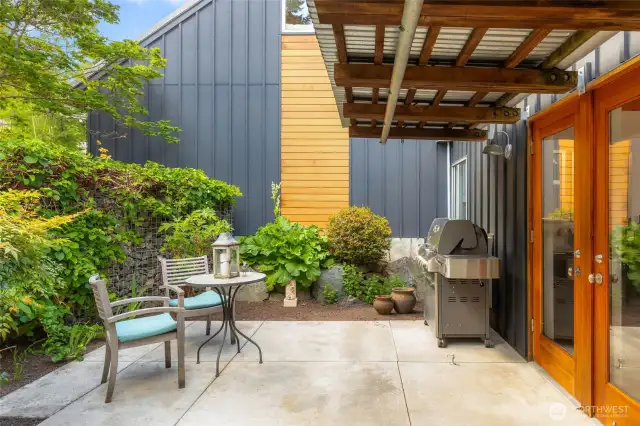 French doors lead from dining area to patio with BBQ.