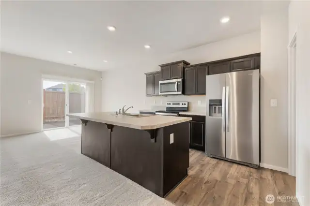 Open kitchen, fridge to stay, huge walk in pantry to the right.