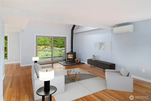 Another view of the living room facing west, with the covered deck in the background. The cozy wood stove was just inspected and it heats the whole condo. A newer mini-ductless both heats and cools the room. Lovely!