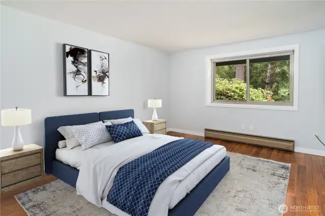The spacious primary bedroom has a newer window overlooking the woods and golf course.