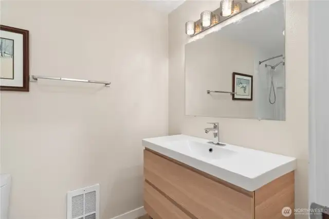 The updated full hallway bathroom has the same cabinetry and fixtures as the primary bedroom bath has, creating a sense of spaciousness and harmony.