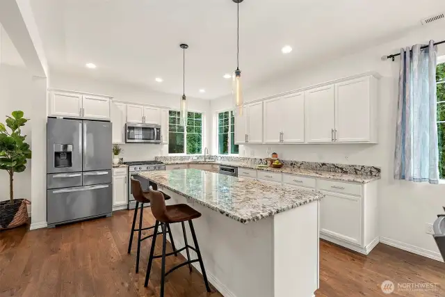 Gorgeous granite countertops, large center island, energy efficient stainless steel appliances, breakfast bar, sleek white cabinetry, tons of storage.