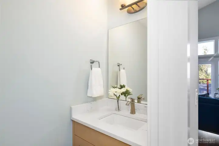 Convenient powder bath with modern finishes, perfect for visitors.