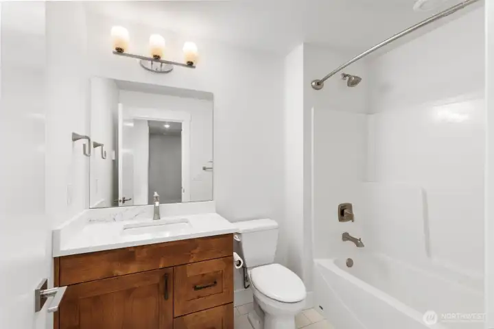 Bright full bath on lower level with modern vanity, tub/shower combo.