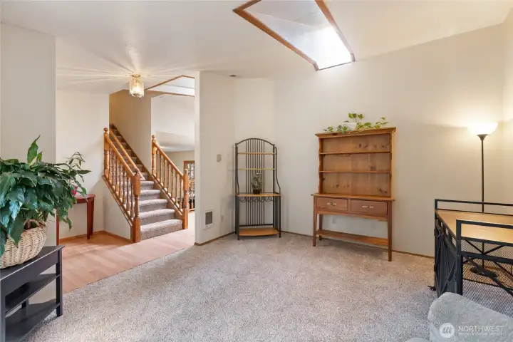 Living room or office off the front entry with a skylight that lends natural light to the room.