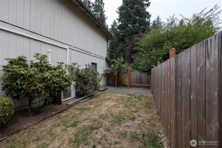 The side yard is fenced separately from the back yard. There is a man door in the gate that leads to the front driveway. The man door into the garage is also here.