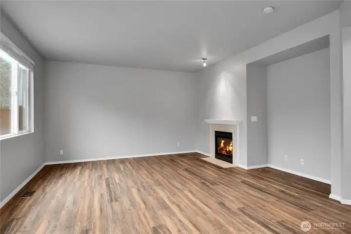 Family room with gas fireplace and LVP flooring opens to kitchen and eating area