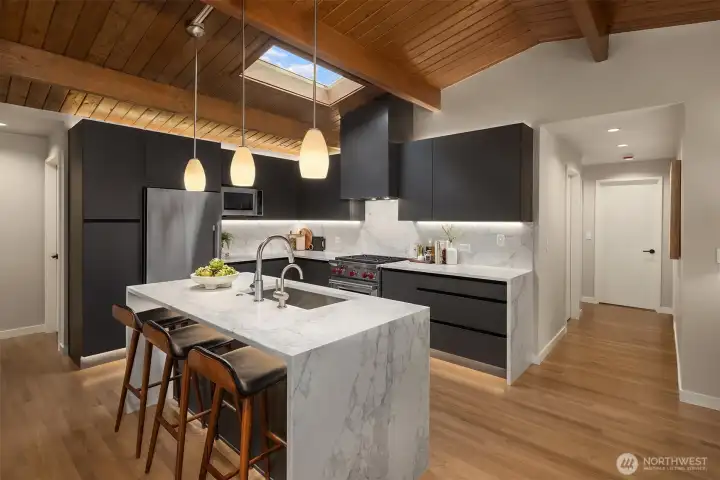 The east hallway brings you to the private primary suite. The west side leads to a powder room, full bathroom and two spacious additional bedrooms.