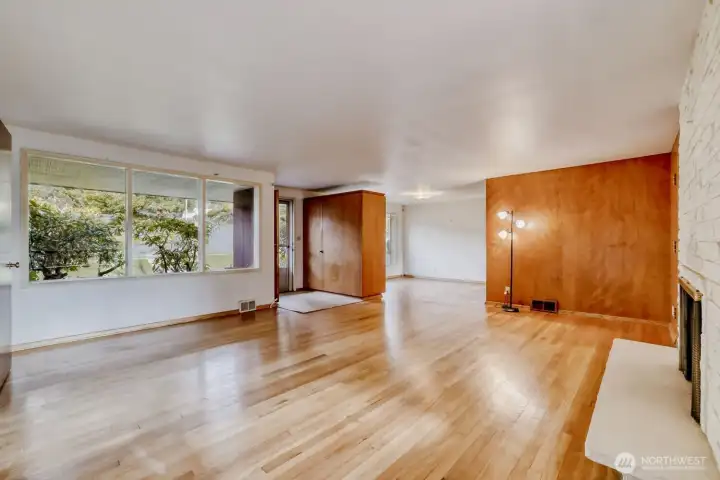 Original hardwood floor spans the main floor, including Living Room, Dining Room, hallway, and both Bedrooms. This Living Room has a great open feel, with the expanse of windows letting in all that natural light.