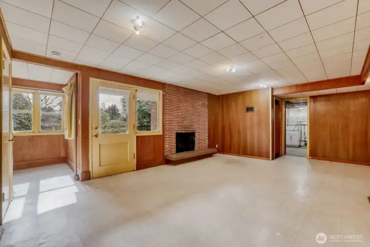 Downstairs Daylight Basement. Rec Room/Game Room with woodburning fireplace and plenty of natural light. Door leads to patio and nicely landscaped backyard. The camelias are in bloom and are just beautiful!