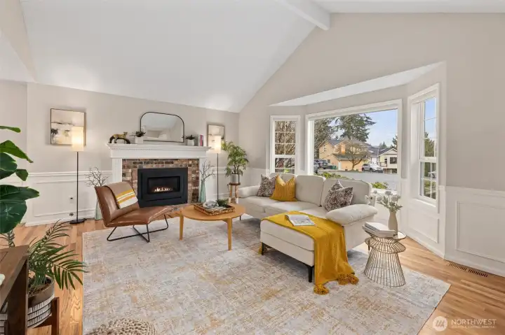 Great room with vaulted ceilings, gleaming hardwood, wainscoating and gas fireplace.