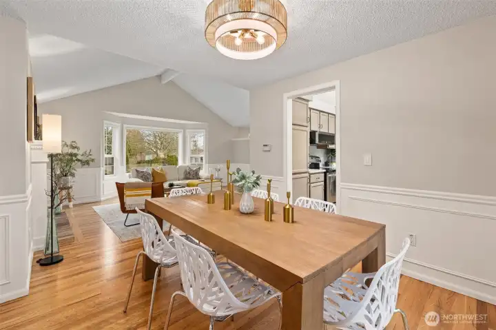 Formal dining room with wainscoating and stylish light fixture.