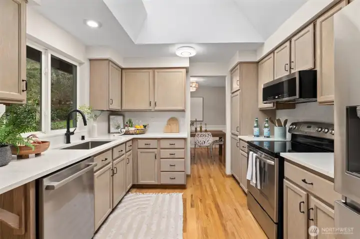 Recently refreshed kitchen with quartz counters, undermount stainless sink and black faucet.