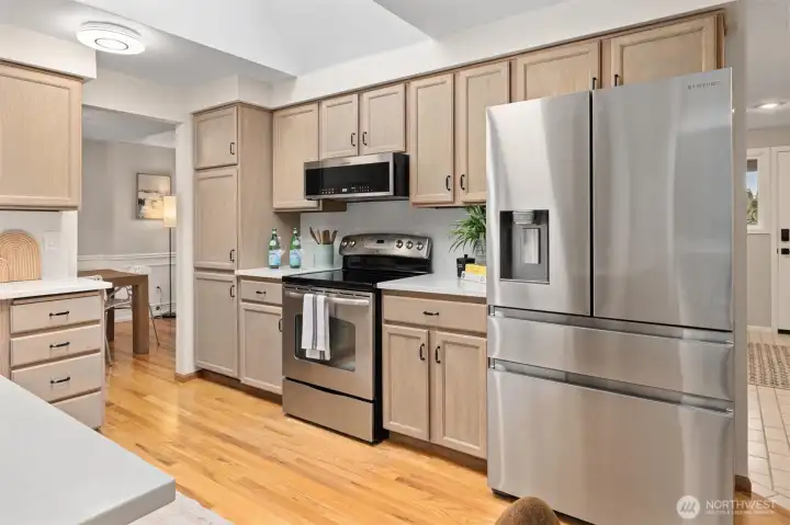 Well lit kitchen with adjacent formal dining room.