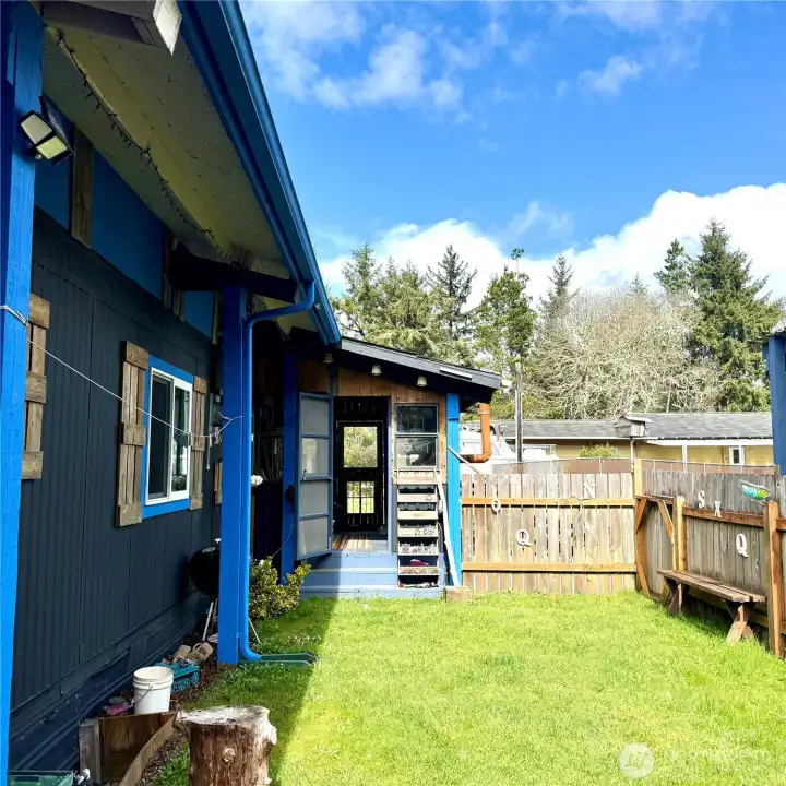 small fenced in yard with door leading to enclosed porch