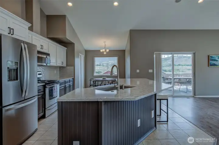 Updated kitchen featuring quartz countertops, stainless steel appliances, and abundant cabinetry with river views. Updated kitchen featuring quartz countertops, stainless steel appliances, and abundant cabinetry with river views.