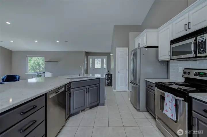 Bright kitchen with eating nook and large windows capturing natural light and surrounding views. Bright kitchen with eating nook and large windows capturing natural light and surrounding views.