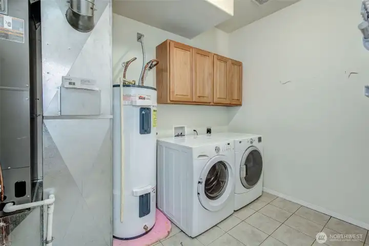 Dedicated laundry room with storage and practical workspace. Dedicated laundry room with storage and practical workspace.