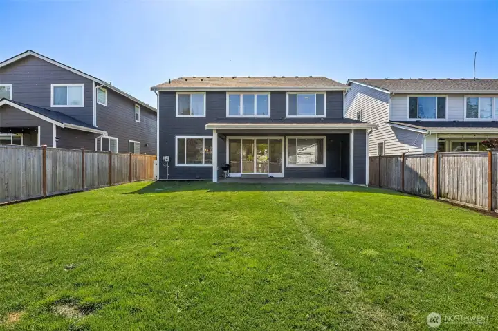 Fully fenced backyard with sprinklers.