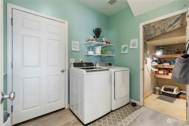 updated main floor laundry room has newer washer & dryer, tons of storage and folding counter.