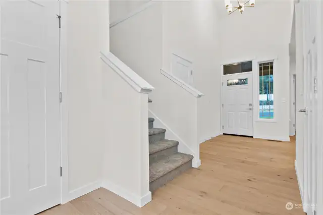 Entry way with high ceilings and hardwood flooring. Photo for illustration only of similar home, not actual.