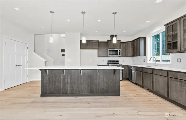 Open concept kitchen. Oversized center island, quartz countertops. Photo for illustration only of similar home, not actual.