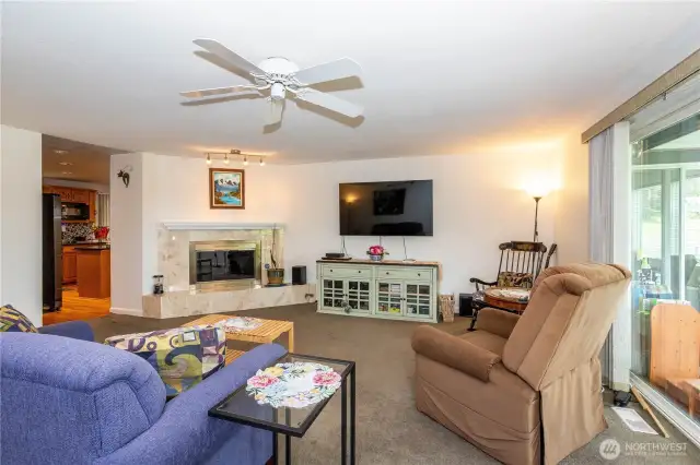 Kitchen leads to oversized family room, with toasty gas fireplace insert; slider at right leads to covered deck.