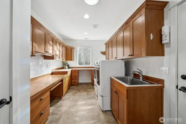 What a great space! Laundry room with sink and so much counter space and storage for your hobby of choice or office.