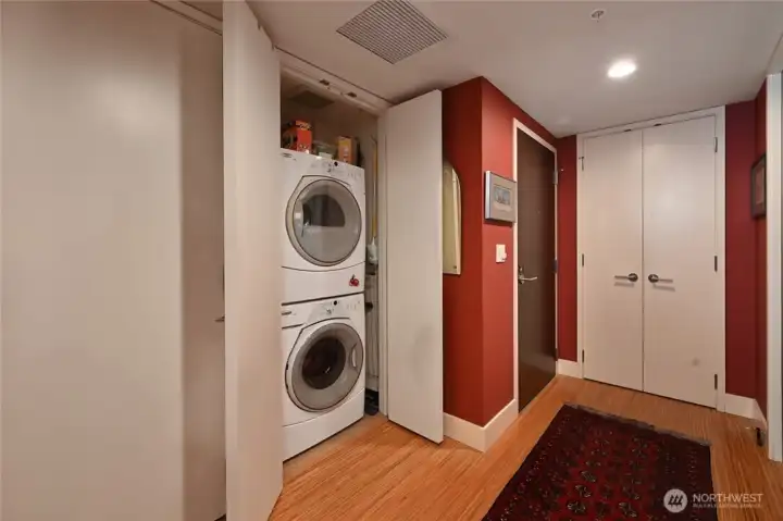 This shows the entry door (brown one)  and washer and dryer. And huge pantry (the double white doors)