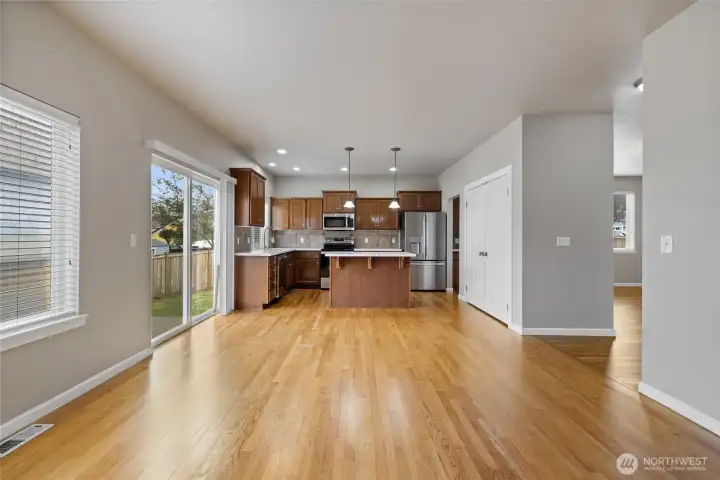looking into the open kitchen past the real wood floors