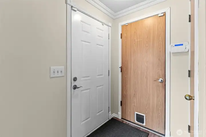 Front door, entry to garage and coat closet to right