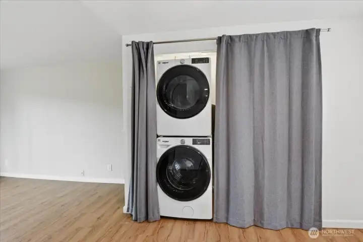 It conceals a brand new full size stackable Whirlpool washer and dryer with shelving to the right.