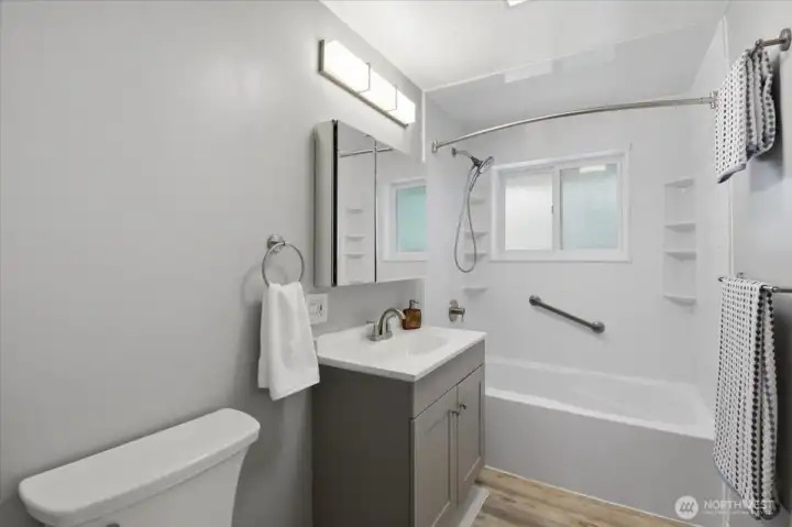 This stylish bath remodel began in 2023 with the bathtub installation completed in 2025. It features a tiled surround and handy built-in shelving. EVERYTHING is new!