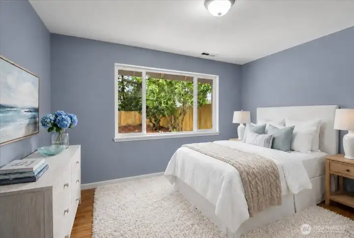 This bedroom in the main home is one of 3 and it enjoys a tranquil view of the lilac trees in the secluded backyard.