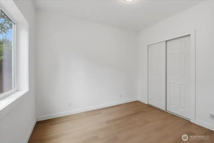 The 2nd bedroom of the DADU has a window that allows for southern natural lighting. It offers a double closet and luxury vinyl plank flooring that is found throughout the home.