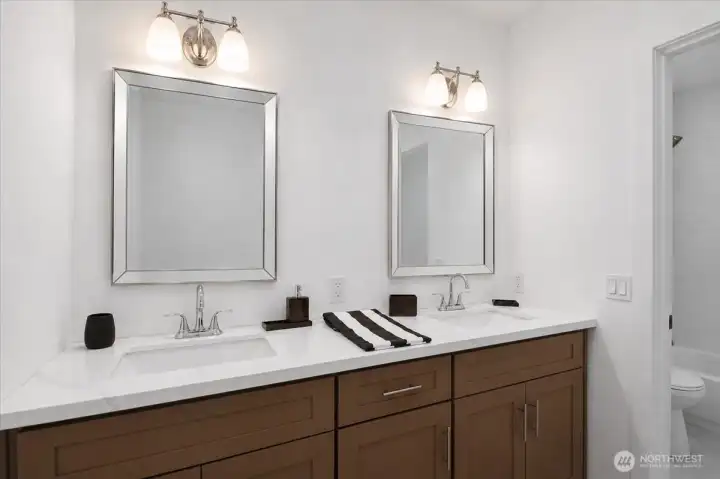 The DADU bathroom enjoys double sinks, a quartz countertop, and vanity lighting.